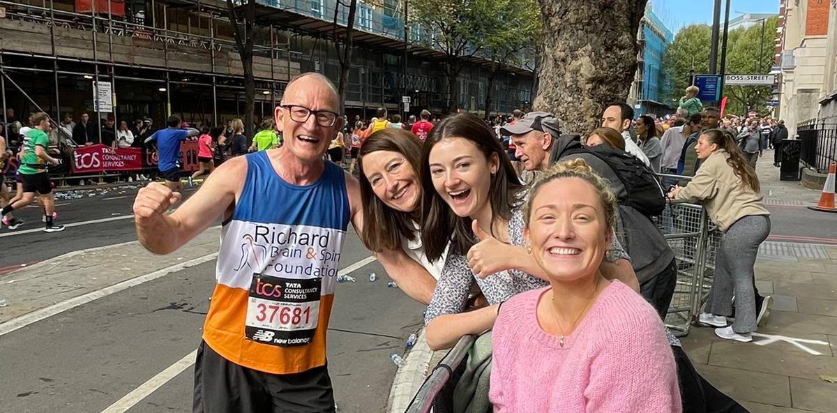 A London Marathon runner greets his family at the sidelines
